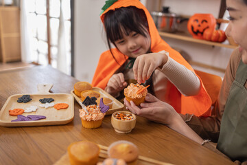 Happy halloween, Mother and her daughter having fun at home. Happy Family preparing for Halloween. Mum and child cooking festive fare in the kitchen Happy family preparing for Halloween.