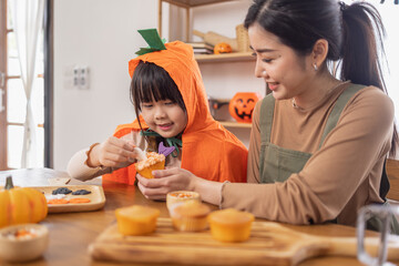 Obraz na płótnie Canvas Happy halloween, Mother and her daughter having fun at home. Happy Family preparing for Halloween. Mum and child cooking festive fare in the kitchen Happy family preparing for Halloween.