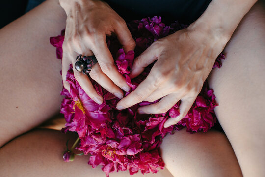 Anonymous woman touching gently bright pink flowers