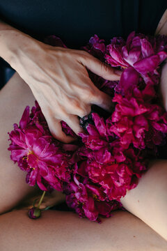Anonymous woman immerce fingers into flowers - masturbation concept
