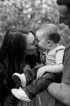 black and white photo of mother kissing her toddler son on the mouth
