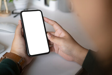 Cropped shot businessman using smart phone while sitting at his workplace..