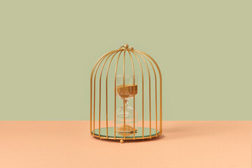 Golden birdcage with hourglasses inside.