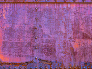peeling blue, orange and purple paint over rusty metal
