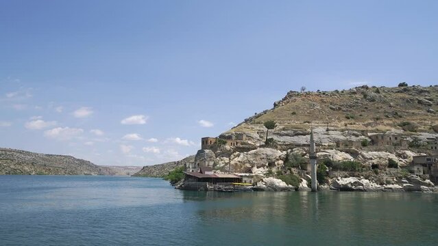 Water reflecting the sky and sun rays on the Euphrates, authentic earthen houses, an idyllic place, Halfeti, Turkey