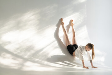 Female acrobat showing her capabilities in studio
