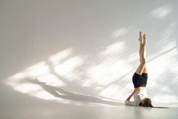 Female acrobat showing her capabilities in studio