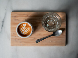 Espresso and water on wooden tray