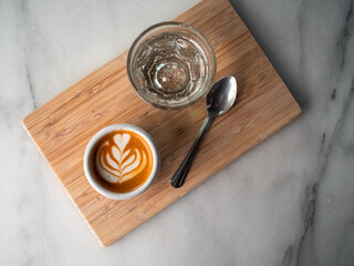 Espresso and water on a wooden angled tray