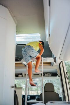 Unrecognizable boy walking down the stairs inside a camper