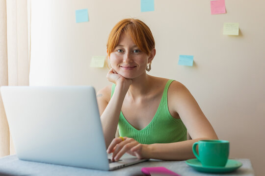 beautiful girl working on a laptop and looking at the camera
