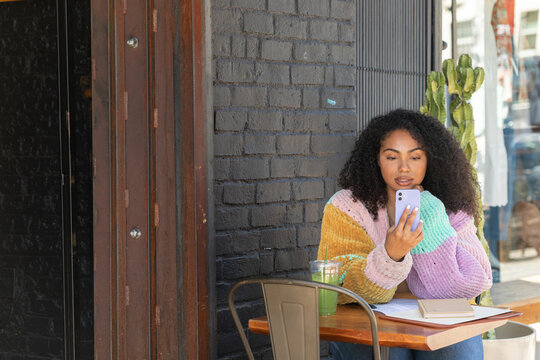 Stylish young woman working outside at a cafe