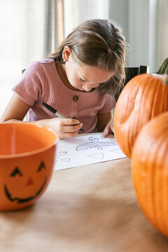Girl Draws Out Pumpkin Faces