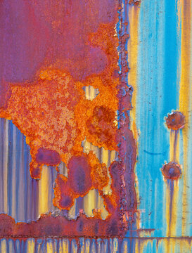 peeling multi-colored paint over rusty metal