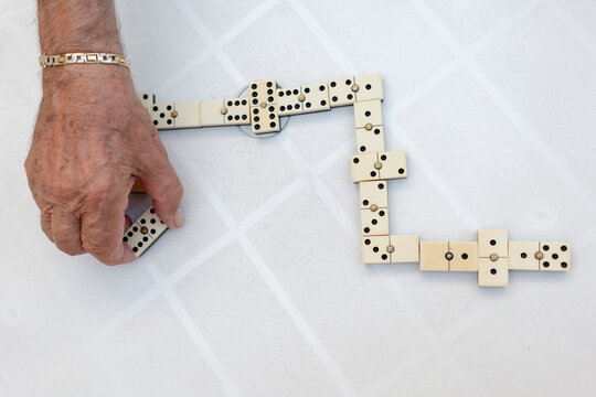 Old man playing dominoes in a residence