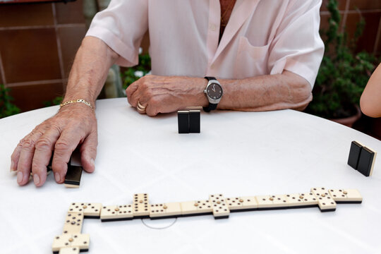 Old man playing dominoes in a residence