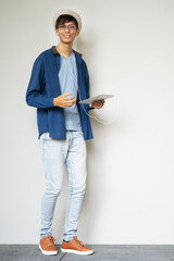 Full body young man standing against the wall.