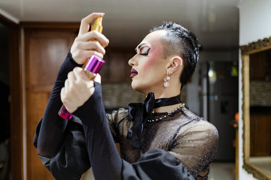 Drag queen applying makeup fixer on her face