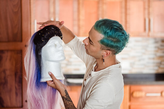 Non binary man looking at a wig