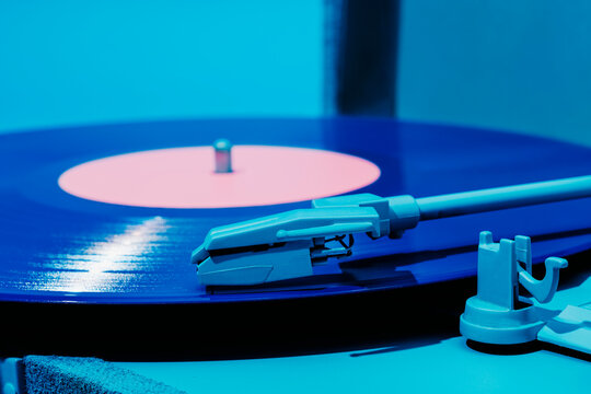 violet vinyl disc being played in a blue turntable