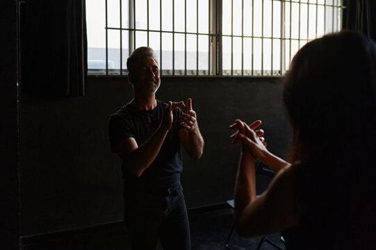 Mature modern dancers clapping during rehearsal