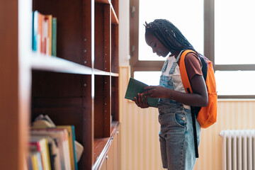 Student reading a book in a library