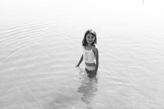 black and white photo of child in lake