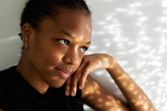 Pensive African woman indoor sunlight portrait