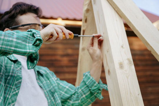 Female carpenter at work with a screwdriver in the backyard