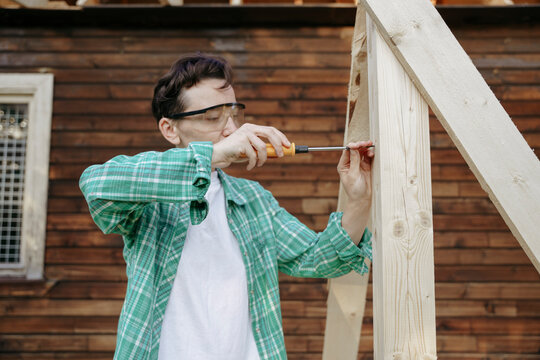 Female carpenter at work with a screwdriver in the backyard