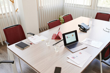 Laptop and paperwork on an boardroom table