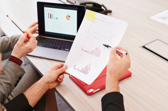 Businesspeople analyzing graphs in an office