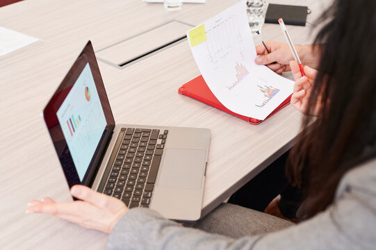 Businesspeople comparing graphs in an office