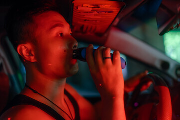 Asian man shaves with electric shaver