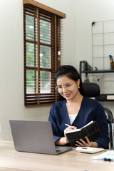 Asian woman working with laptop in her office. business financial concept.