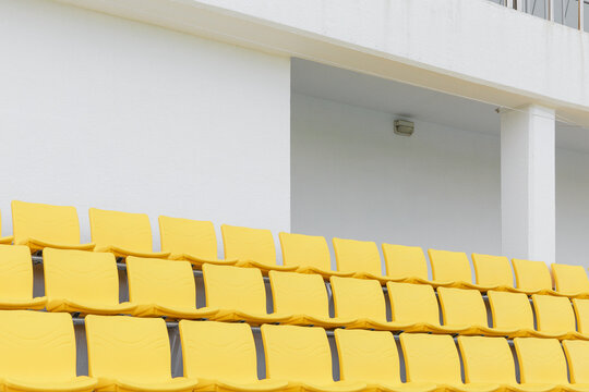 White walls and empty yellow stands in the stadium.