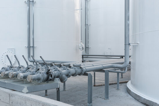 Close-up of metal pipes and valves connected to the storage tank.