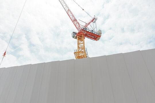 Barrier and tower crane low angle at construction site.
