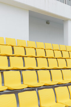 White walls and empty yellow chairs in the stadium.