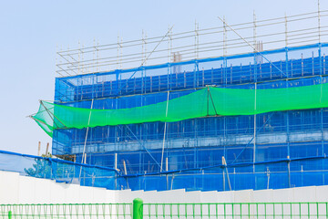 A blue safety net is installed at the construction site.