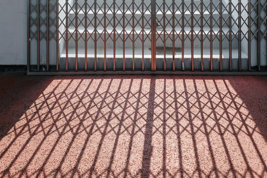 Locked metal gates and shadows.
