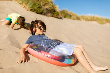 Two brothers playing by dunes