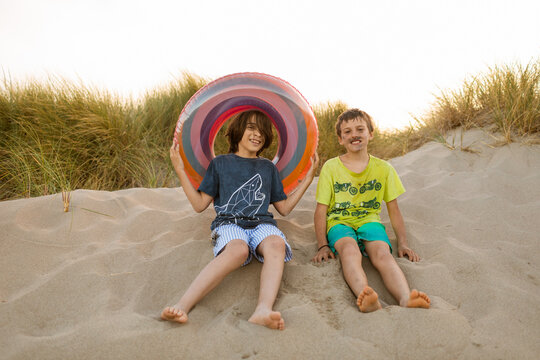 Funny kids at the beach dunes with float tube