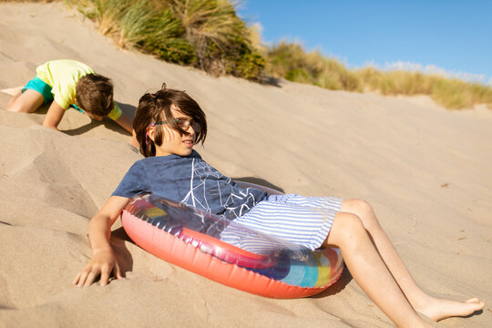 Two brothers playing by dunes
