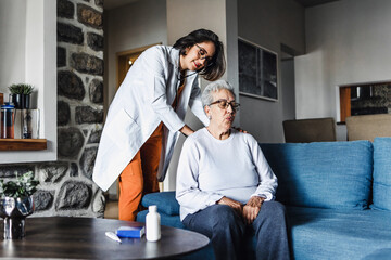 hispanic elderly woman with doctor or nurse during home visit in Mexico Latin America