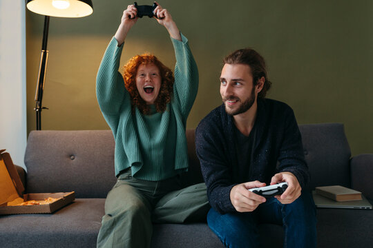 Couple enthusiastically cheers during video game.