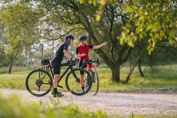 Cyclists on bikes pointing away in countryside