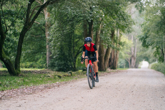 Female cyclist riding bike near trees