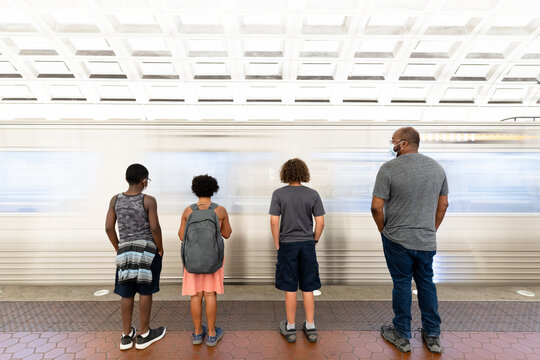 Father And Children Wait At Train Station