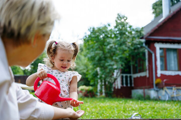 Mom and daughter watering the garden